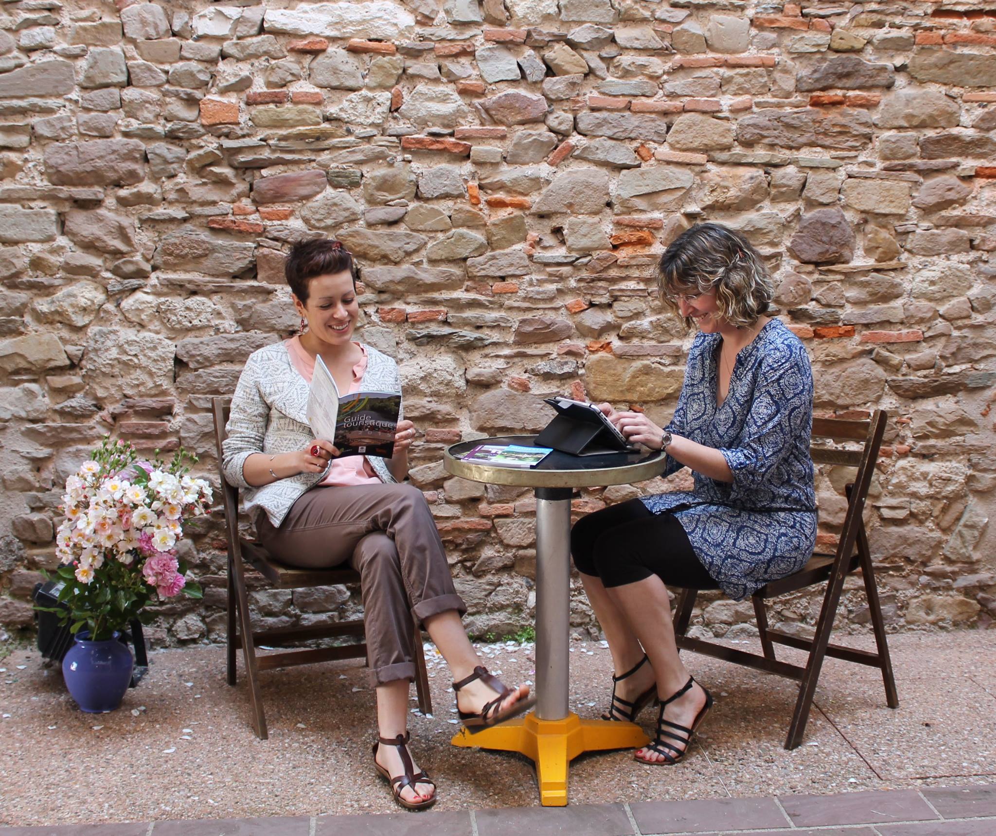 Deux touristes profitant de la borne WiFi à Monestiés